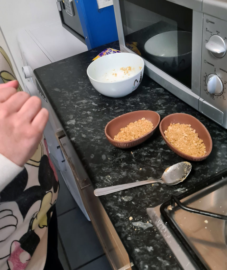 Adding the biscuit base inside Easter egg halves