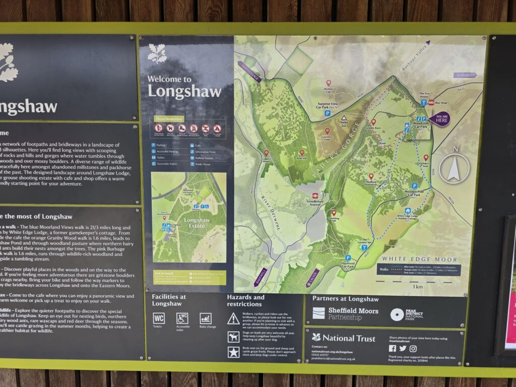 An information board and map for visitors at Longshaw Estate, detailing walking routes and points of interest in the surrounding area.